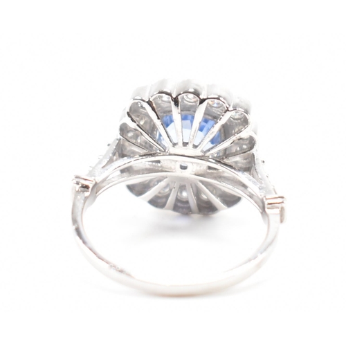 301 - A white gold sapphire and diamond halo ring. The ring set with a cushion cut sapphire surrounded fra... 