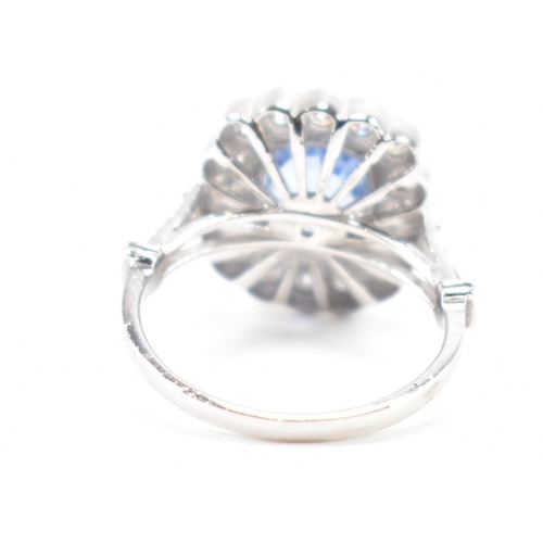 301 - A white gold sapphire and diamond halo ring. The ring set with a cushion cut sapphire surrounded fra... 