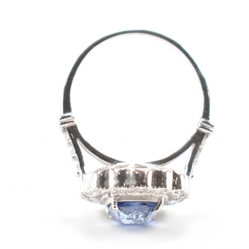 301 - A white gold sapphire and diamond halo ring. The ring set with a cushion cut sapphire surrounded fra... 