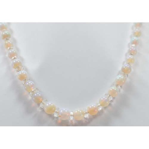 305 - A vintage opal and rock crystal necklace. The necklace being alternately threaded with round opal be... 