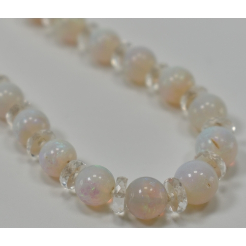 305 - A vintage opal and rock crystal necklace. The necklace being alternately threaded with round opal be... 