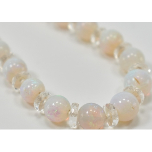 305 - A vintage opal and rock crystal necklace. The necklace being alternately threaded with round opal be... 