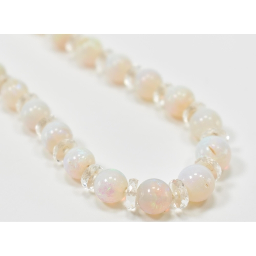 305 - A vintage opal and rock crystal necklace. The necklace being alternately threaded with round opal be... 