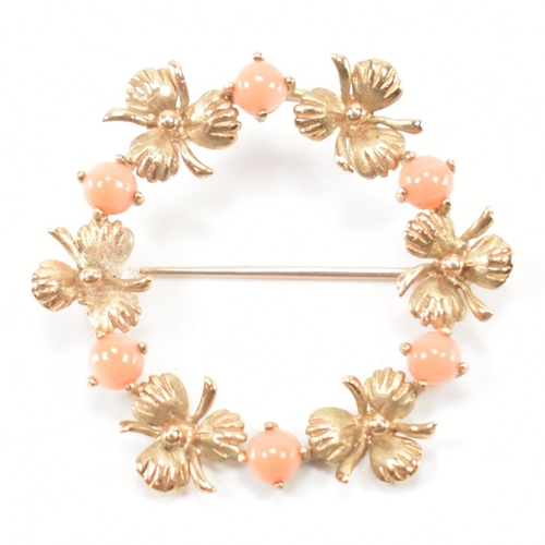 533 - A hallmarked 9ct gold and coral brooch. The brooch of round form with floral detailing being set wit... 