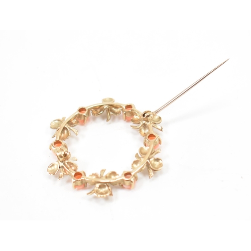 533 - A hallmarked 9ct gold and coral brooch. The brooch of round form with floral detailing being set wit... 