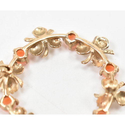 533 - A hallmarked 9ct gold and coral brooch. The brooch of round form with floral detailing being set wit... 