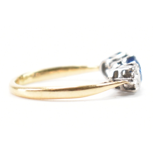 201 - An 18ct gold sapphire and diamond three stone ring. The ring being set with a round cut blue sapphir... 