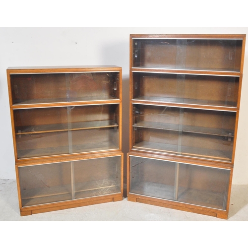 1163 - Two retro vintage mid 20th century Minty glazed teak cased bookcases having a series of glass slidin... 