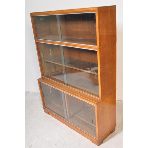 1163 - Two retro vintage mid 20th century Minty glazed teak cased bookcases having a series of glass slidin... 