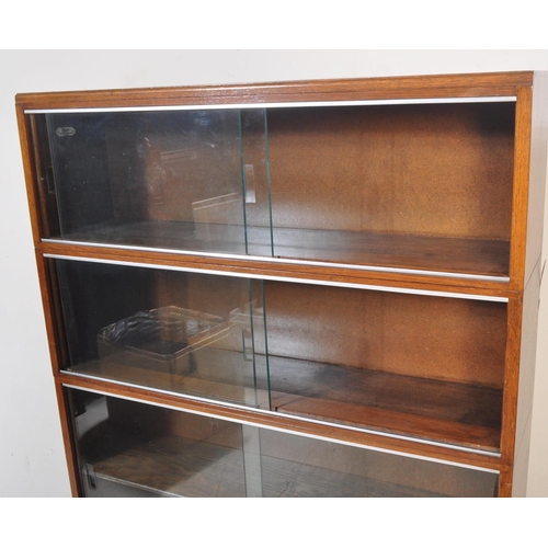 1163 - Two retro vintage mid 20th century Minty glazed teak cased bookcases having a series of glass slidin... 