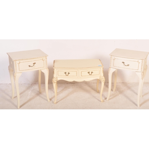 1164 - A pair of 20th century Louis XV style cream painted bedside tables. The pair of bedside cabinets hav... 