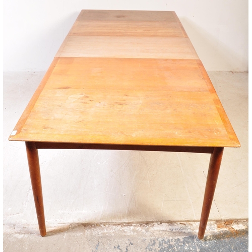 1185A - A mid century Danish large teak triple leaf extending dining table. Raised on tapering legs  with ex... 