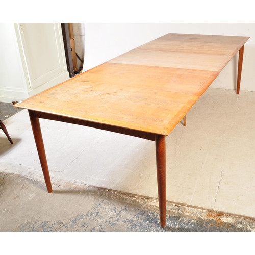 1185A - A mid century Danish large teak triple leaf extending dining table. Raised on tapering legs  with ex... 