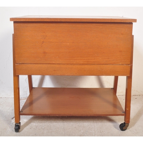 1192 - British Modern Design - A mid century teak wood sewing box being raised on squared legs with fielded... 