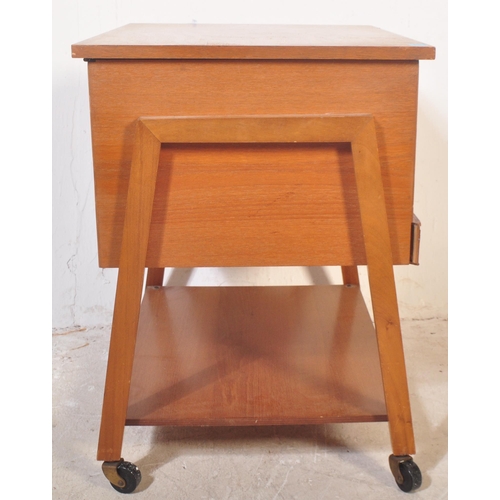 1192 - British Modern Design - A mid century teak wood sewing box being raised on squared legs with fielded... 