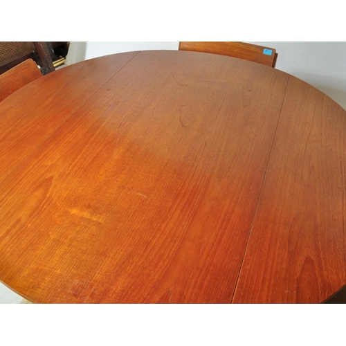 1240a - A retro vintage mid 20th Century teak drop leaf table with four chairs. The table of circular form w... 