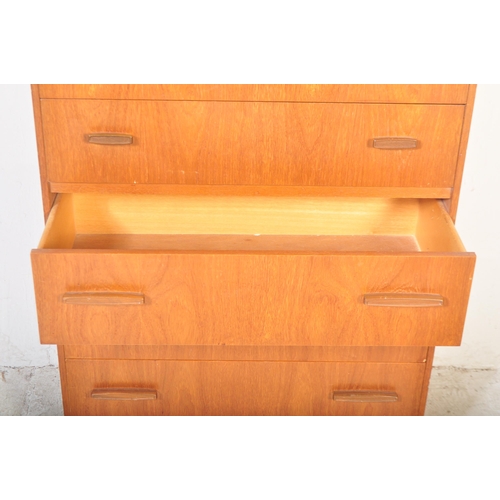 1302 - A retro mid 20th century teak chest of drawers having a bank of five drawers with stained wood recta... 