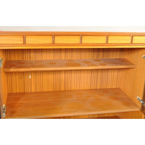 1321 - A mid century, circa 1970's / 1980's faux teak wood high board sideboard. Raised on an inset plinth ... 