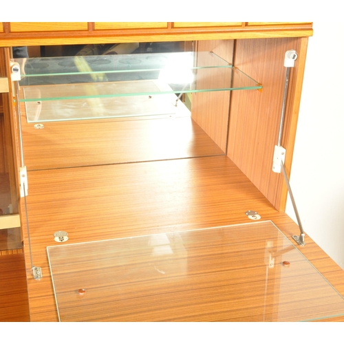 1321 - A mid century, circa 1970's / 1980's faux teak wood high board sideboard. Raised on an inset plinth ... 