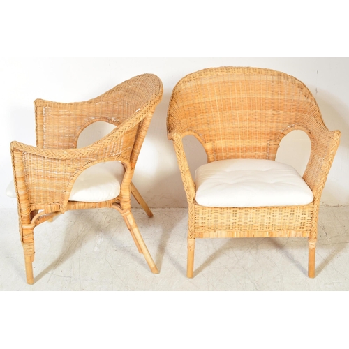 1325a - A pair of vintage 20th century wicker conservatory chairs having spoon back with raised elbow rests ... 