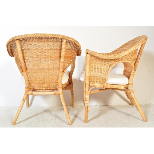 1325a - A pair of vintage 20th century wicker conservatory chairs having spoon back with raised elbow rests ... 