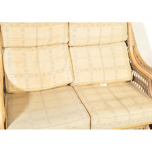 1334 - A contemporary double seater cane bamboo conservatory sofa having wicker rolled armrests over double... 