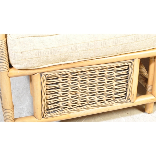 1334 - A contemporary double seater cane bamboo conservatory sofa having wicker rolled armrests over double... 