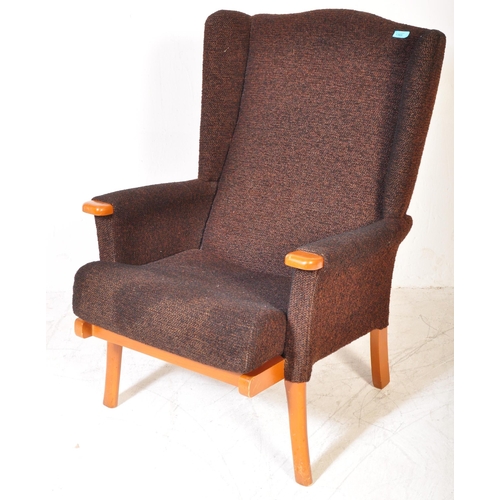 1365 - Mid-century upholstered armchair in the manner of Parker Knoll. Raised on tapering legs with stretch... 