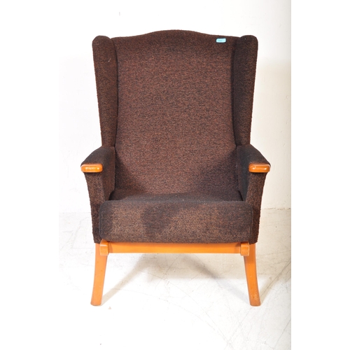 1365 - Mid-century upholstered armchair in the manner of Parker Knoll. Raised on tapering legs with stretch... 