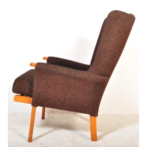 1365 - Mid-century upholstered armchair in the manner of Parker Knoll. Raised on tapering legs with stretch... 