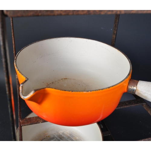 1385a - A series of four vintage 20th century cast iron Le Creuset cooking pots / saucepans in red and orang... 