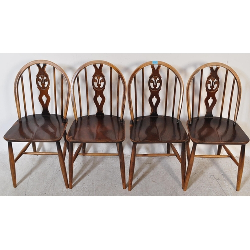 1387 - A Set of 20th century Ercol fleur de Lys beech and elm dining chairs with arched back rests, spindle... 