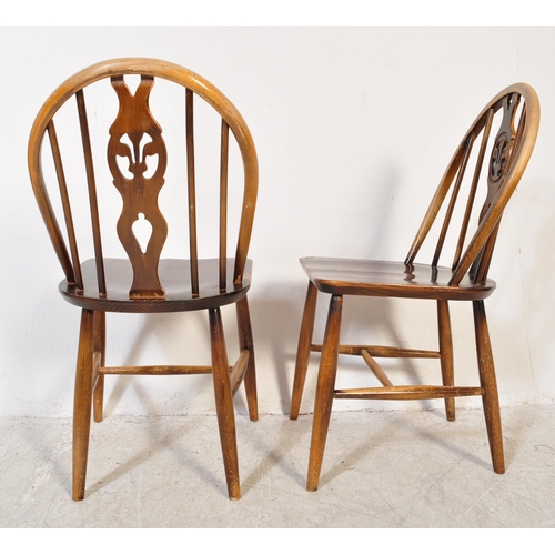 1387 - A Set of 20th century Ercol fleur de Lys beech and elm dining chairs with arched back rests, spindle... 