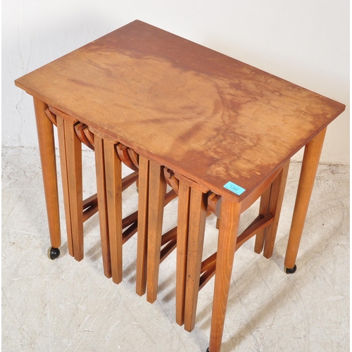 1395 - A retro 1970`s teak quartetto nest of tables, the large rectangular table raised on castors supporti... 