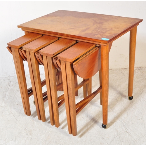 1395 - A retro 1970`s teak quartetto nest of tables, the large rectangular table raised on castors supporti... 