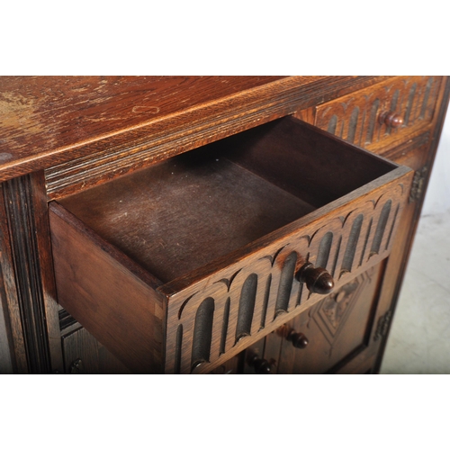 1445 - A Wood Bros Old Charm type Jacobean revival oak dresser. Raised on a plinth base with twin ' linen f... 