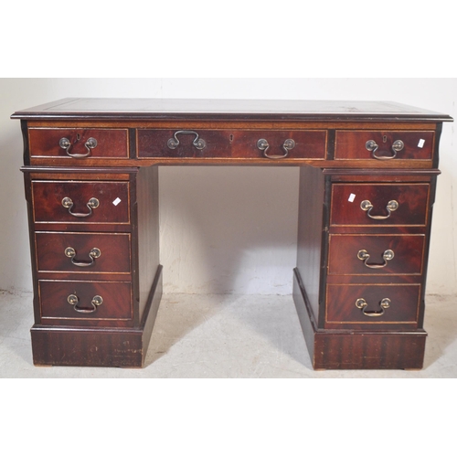 1451 - A 20th century George III style mahogany and leather twin pedestal office desk having a chamfered to... 