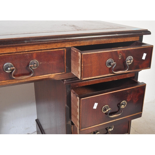 1451 - A 20th century George III style mahogany and leather twin pedestal office desk having a chamfered to... 