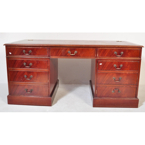 1482 - A 20th century mahogany twin pedestal writing desk. The desk having a red leather skiver to top over... 