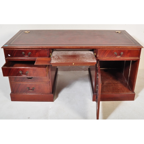 1482 - A 20th century mahogany twin pedestal writing desk. The desk having a red leather skiver to top over... 