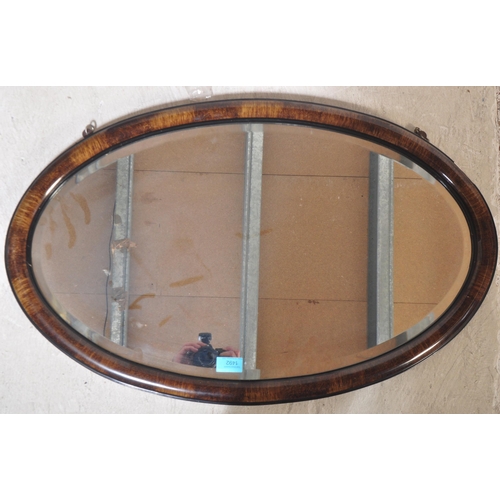 1492 - An early 20th century wall mirror having ovolu faux rosewood cushion frame with  hand painted ebonis... 