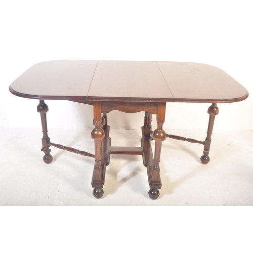 1521 - A 20th century mahogany dining table having two lateral drop leaves raised on turned supports with d... 