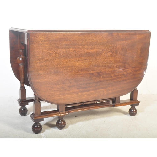 1521 - A 20th century mahogany dining table having two lateral drop leaves raised on turned supports with d... 