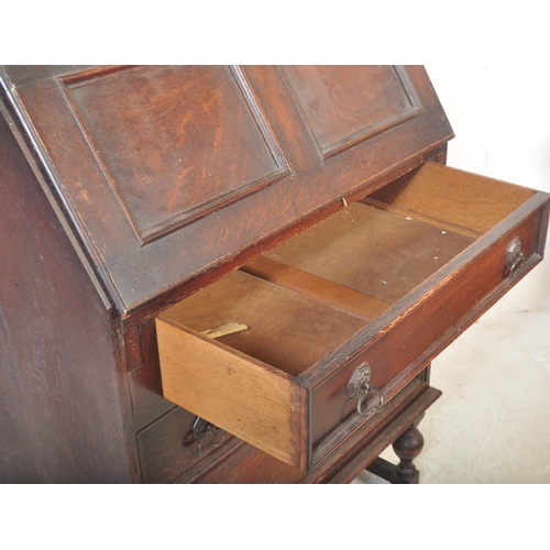 1545 - A vintage 20th Century oak Jacobean revival writing bureau desk. Having a rectangular top, with a sq... 