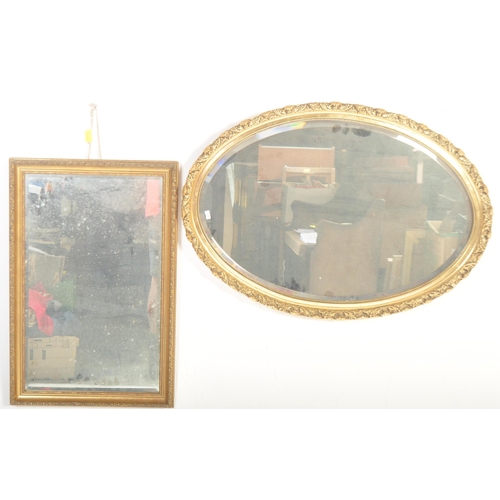 1555 - A pair of gilt framed bevelled edge mirrors. One of oval form with a beaded border and geometric pat... 