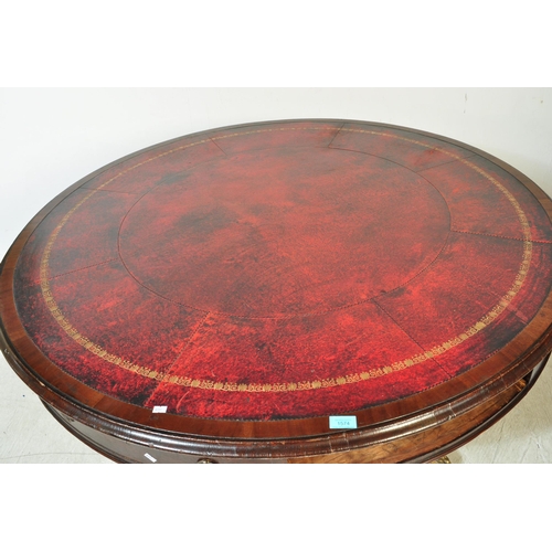 1574 - A late 19th mahogany drum table. With a round circular top, inlaid gilt red leather top with faux dr... 