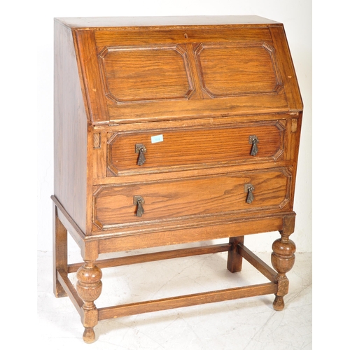 1578 - A 1920’s oak Jacobean revival bureau desk being raised on cup and cover legs with double drawers and... 