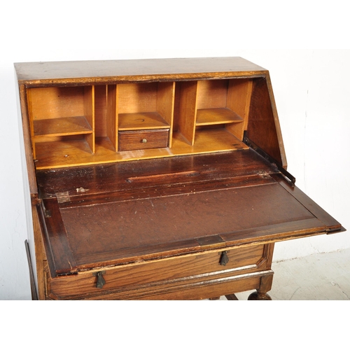 1578 - A 1920’s oak Jacobean revival bureau desk being raised on cup and cover legs with double drawers and... 