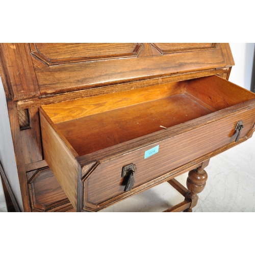 1578 - A 1920’s oak Jacobean revival bureau desk being raised on cup and cover legs with double drawers and... 