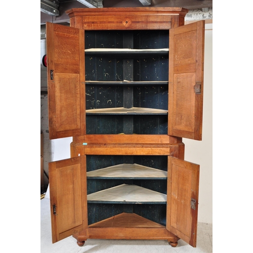 1591 - An 18th century George III country oak double corner cupboard. Raised on bracket feet with twin cupb... 